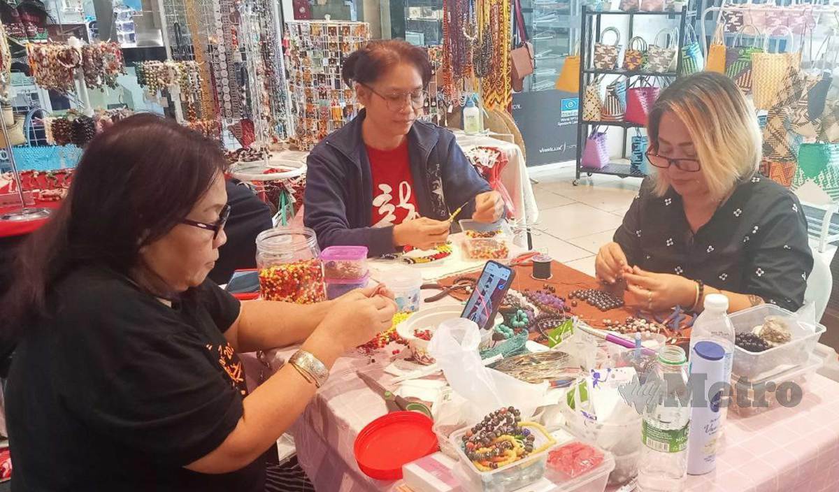 MARIA Chokan (kanan) bersama Stella Niut (tengah) dan Belinda Serey (kiri) menghasilkan kraf tangan tradisional Sarawak untuk dijual kepada pelanggan. FOTO Norsyazwani Nasri