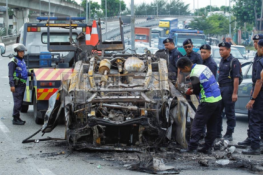 POLIS PDRM bersama polis bantuan LITRAK melakukan kerja pembersihan kereta yang dibakar.