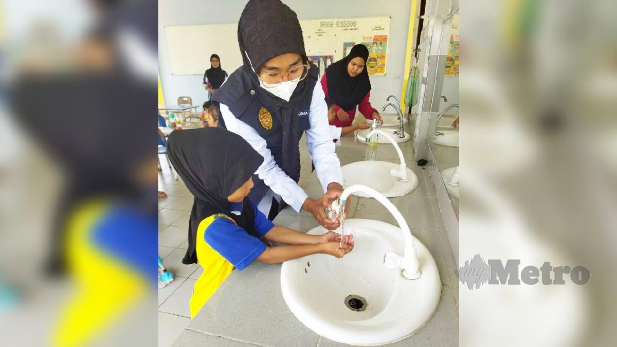 KAKITANGAN Pejabat Kesihatan Daerah (PKD) Pekan mengajar kanak-kanak di pusat asuhan cara mencuci tangan dengan betul.  FOTO Ihsan JKNP.