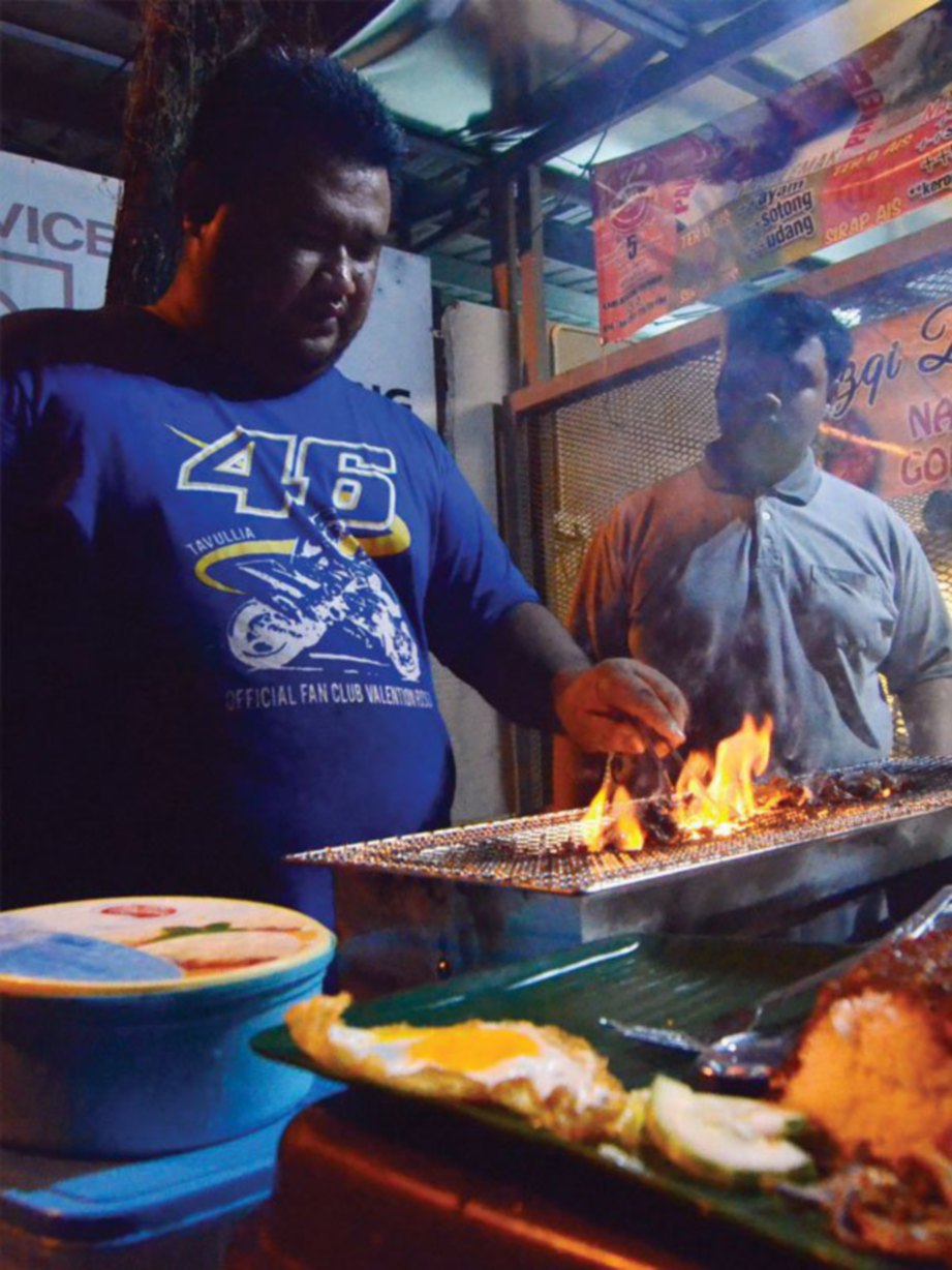 MOHD Zainol Fitri (kiri) membakar hirisan daging kambing.