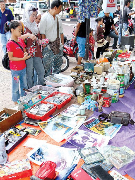 PENGUNJUNG tertarik melihat pelbagai barangan lama dan antik yang dijual Hairol Budiman di Taman Kerang, setiap Sabtu dan Ahad.
