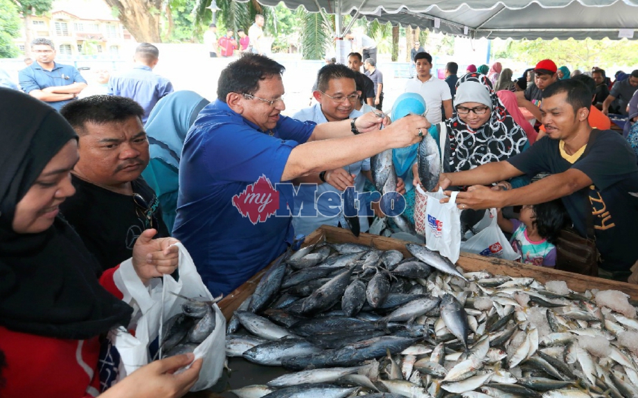 Tengku Adnan membantu orang ramai memilih ikan pada program Jualan Ikan Segar Separuh Harga. FOTO Ahmad Irham Noor 