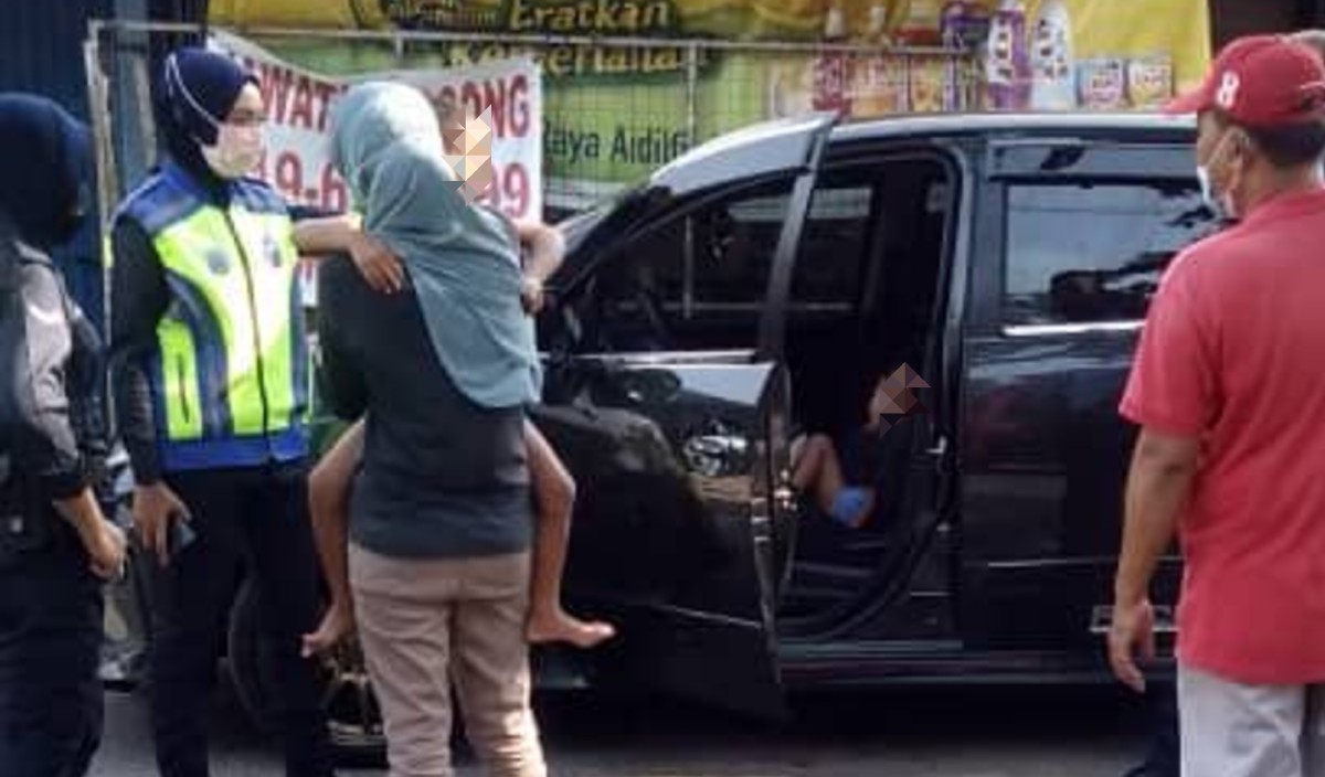 KANAK-KANAK yang terperangkap dalam kereta Produa Alza diselamatkan anggota bomba dan diserahkan kepada ibu mereka. FOTO Ihsan bomba