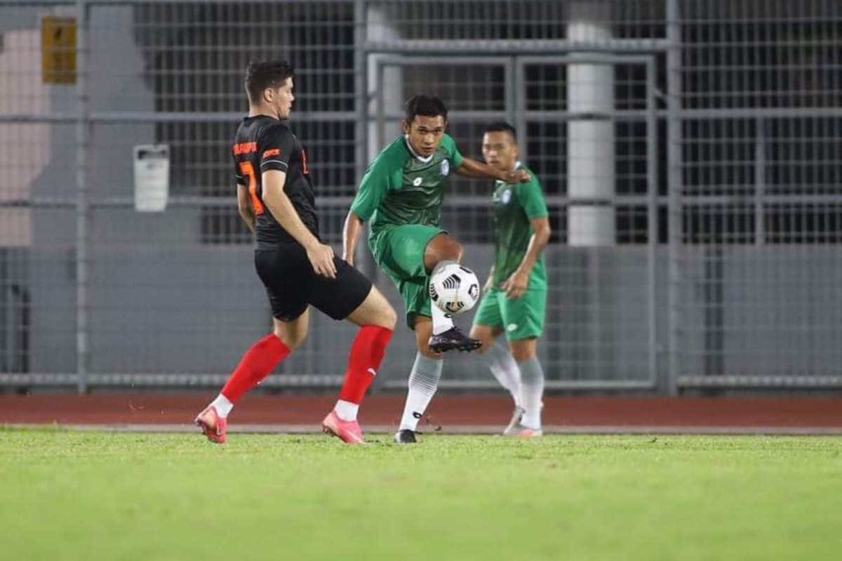 Pemain Sabah, Mohd Azzizan Nordin (kanan) melakukan rembatan sambil dihalang pemain KL United dalam aksi persahabatan malam tadi.