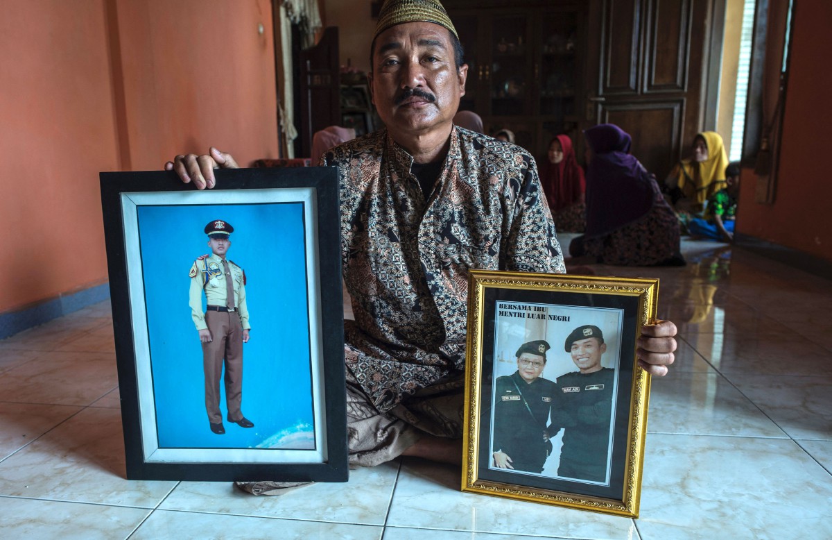 EDY menunjukkan potret anaknya, Leftenan Pertama Muhammad Imam Adi yang bertugas dalam kapal selam KRI Nanggala-402. FOTO AFP.