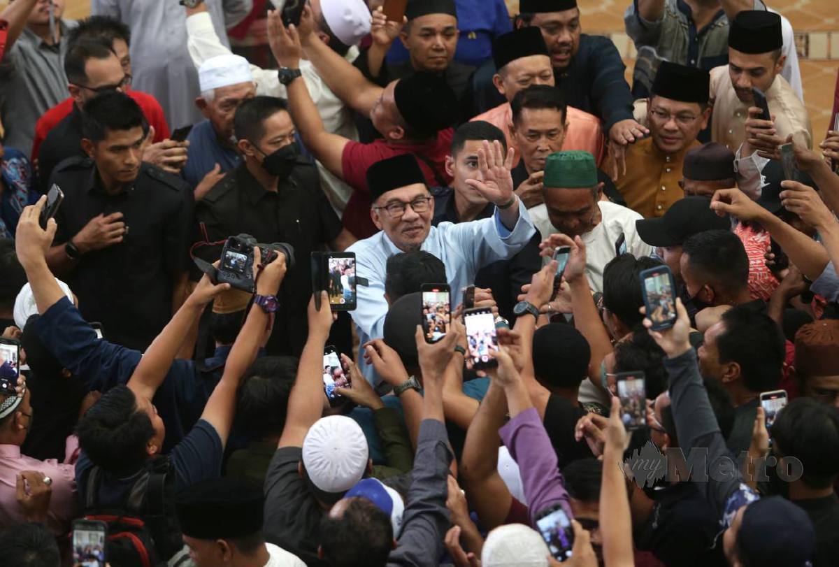 ANWAR bersalaman dengan jemaah selepas menunaikan solat Jumaat di Masjid Kampung Baharu, Kuala Lumpur. FOTO Mohamad Shahril Badri Saali