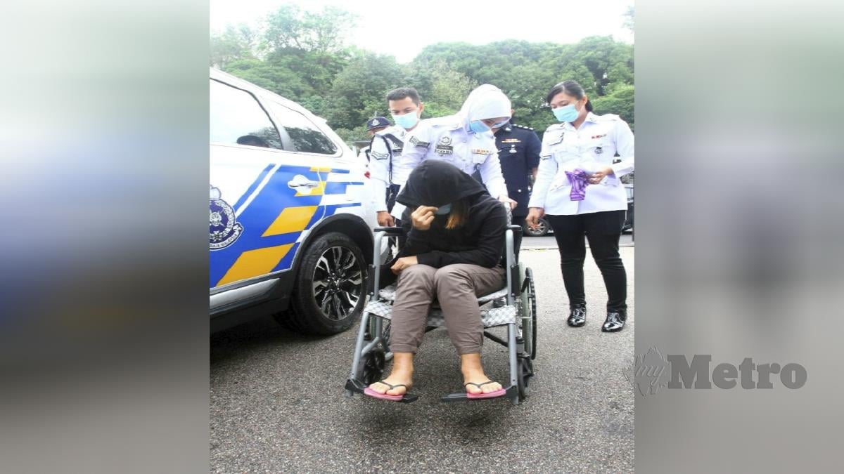 ANGGOTA polis Trafik membawa pemandu Perodua Myvi wanita dengan menaiki kerusi roda yang didakwa di Mahkamah Majistret Johor. FOTO ZAIN AHMED