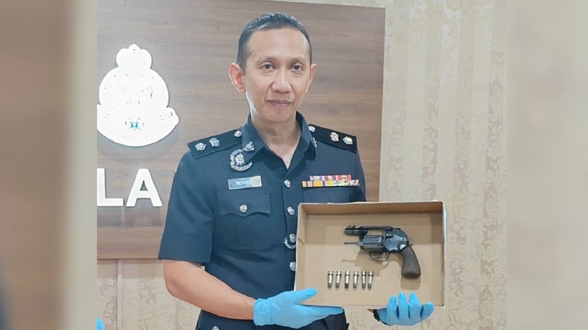 AHMAD Ridhwan menunjuk pistol bersama enam butir peluru hidup yang dirampas daripada seorang juruteknik kilang. FOTO Ihsan IPD Kuala Langat