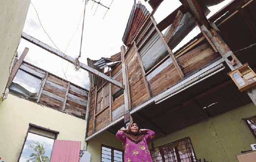 CHE TOM melihat rumahnya yang rosak akibat puting beliung di Kampung Sungai Nonang.