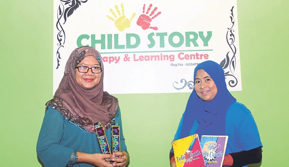 AHLI Terapi Jurukerja Child Story Therapy Center Rohaiza Azreen Saaid (kiri) dan Dazrina cekal perkenalkan kaedah pensel cakar untuk kanak-kanak autisme belajar menulis.
