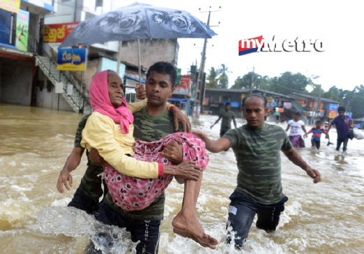 Anggota tentera Sri Lanka memindahkan mangsa banjir di Kaduwela, pinggir Colombo, semalam. Hujan lebat sejak tiga hari lalu, menyebabkan banjir di banyak lawasan di negara itu. - Foto AFP 