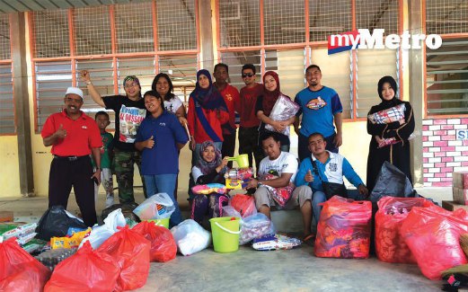 BERSAMA rakan sukarelawan menyerahkan sumbangan kepada sekolah anak Orang Asli di Kuala Lah.