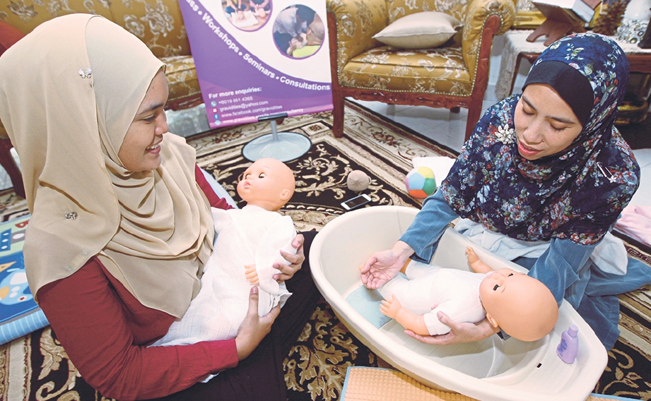 DR Nurzarina menunjukkan cara memandikan bayi kepada Malini.