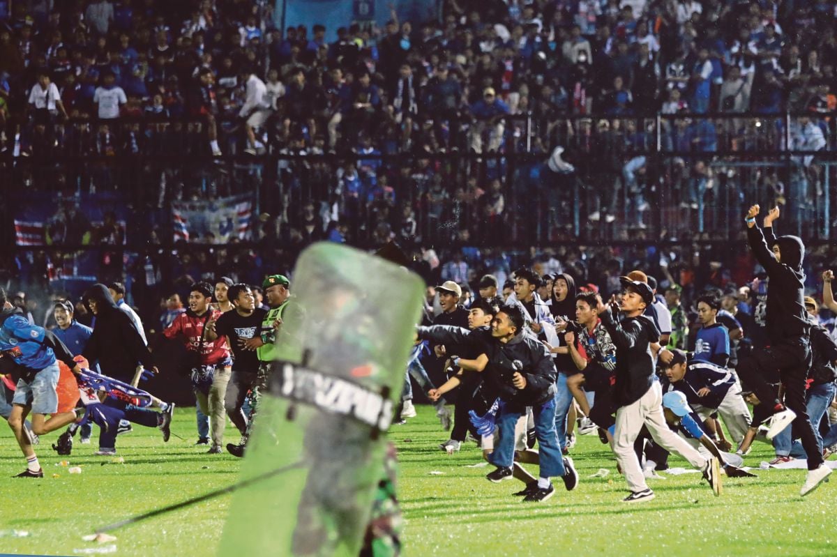 PENYOKONG meluru ke padang selepas perlawanan. FOTO AP 