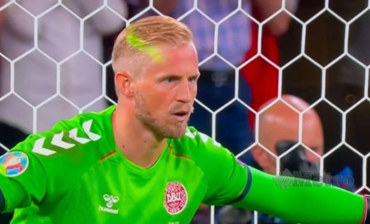 CAHAYA hijau laser jelas kelihatan pada wajah penjaga gol Denmark, Kasper Schmeichel ketika dia bersiap menanti sepakan penalti diambil kapten England, Harry Kane. FOTO Agensi 