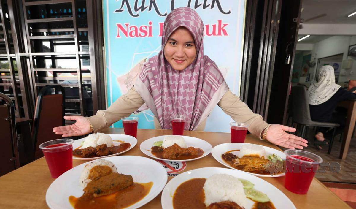 ASMAA Atirah menunjukkan menu dikedainya di Kampung Berangan yang dijual  dengan harga antara RM3 hingga RM5 setiap hidangan juga disertakan dengan air minuman percuma. FOTO Nik Abdullah Nik Omar