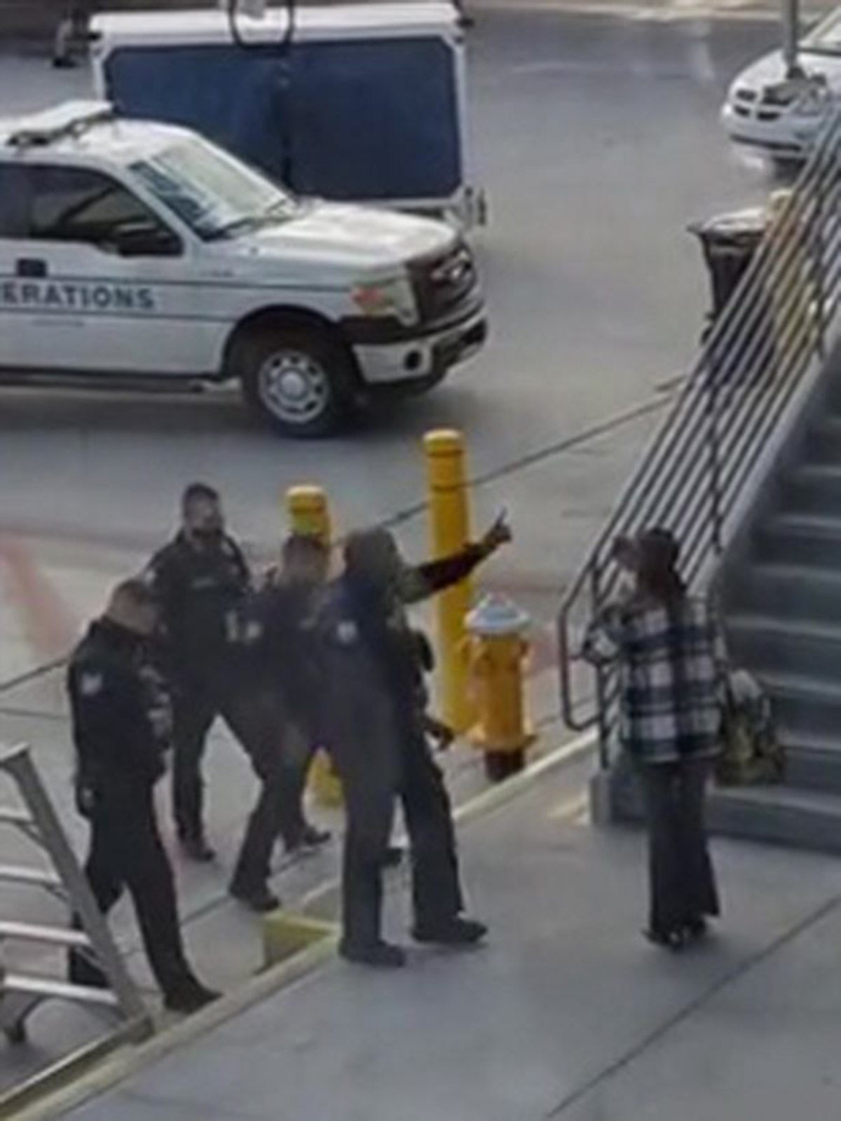 ANGGOTA polis mengarahkan suspek (kanan)  memasuki  bangunan terminal lapangan terbang.  FOTO Agensi