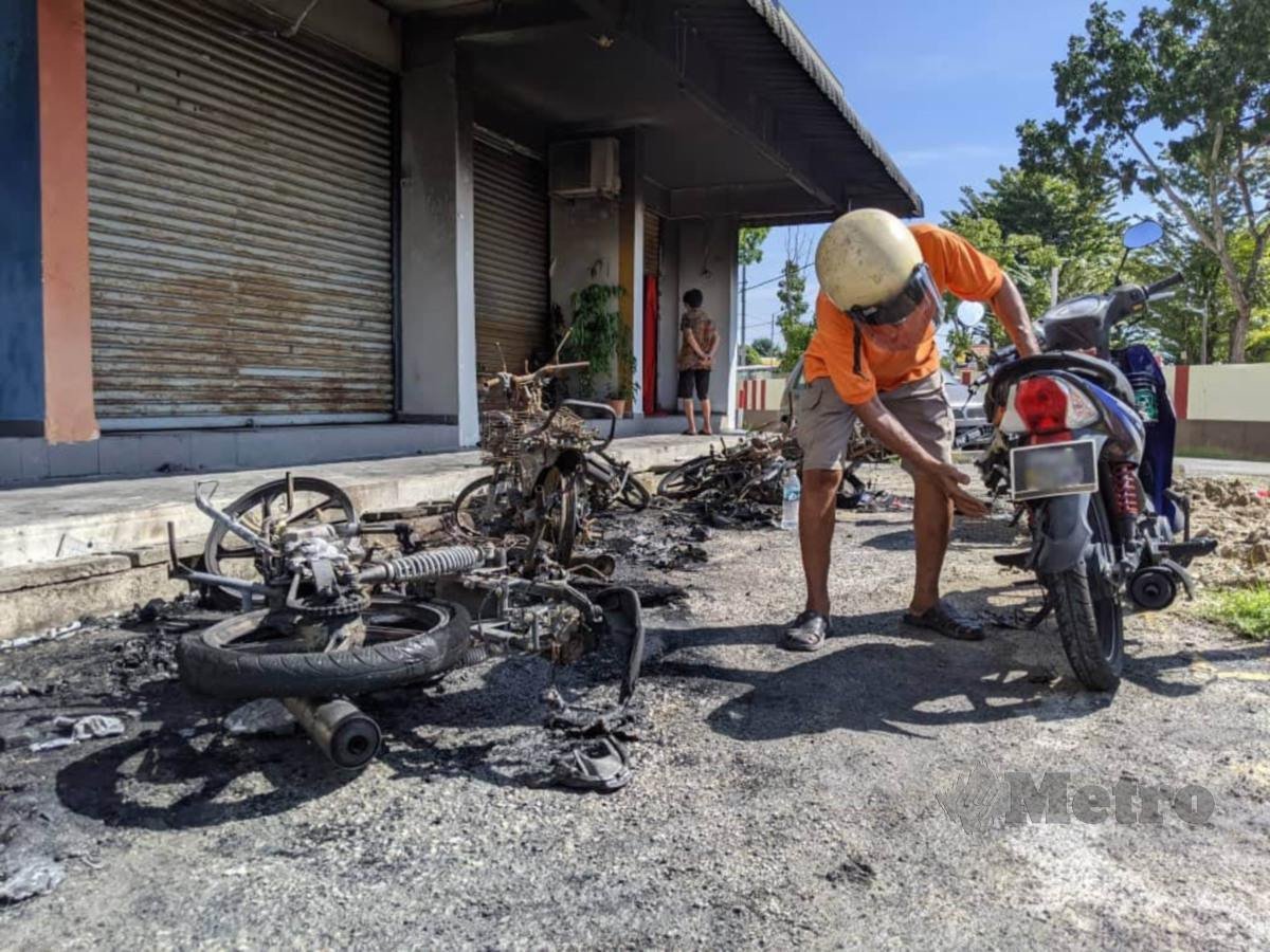 Lee memeriksa motosikalnya yang terbabit dalam kebakaran di Flat Desa Mawar, Lintang Kampung Melayu di sini. FOTO ZUHAINY ZULKIFFLI