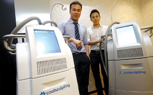 DR Lim (kiri) dan Pengarah Klinik Clique Josh Chua (kanan) menunjukkan mesin CoolSculpting yang digunakan dalam rawatan menyingkir lemak.