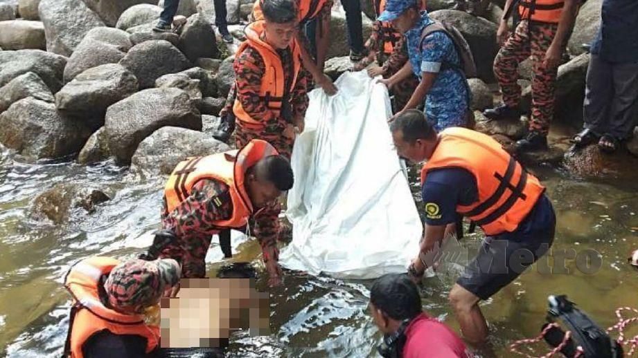 ANGGOTA bomba membawa naik mayat Wan Amirul Nain yang lemas ke tebing sungai . FOTO Ihsan Bomba 