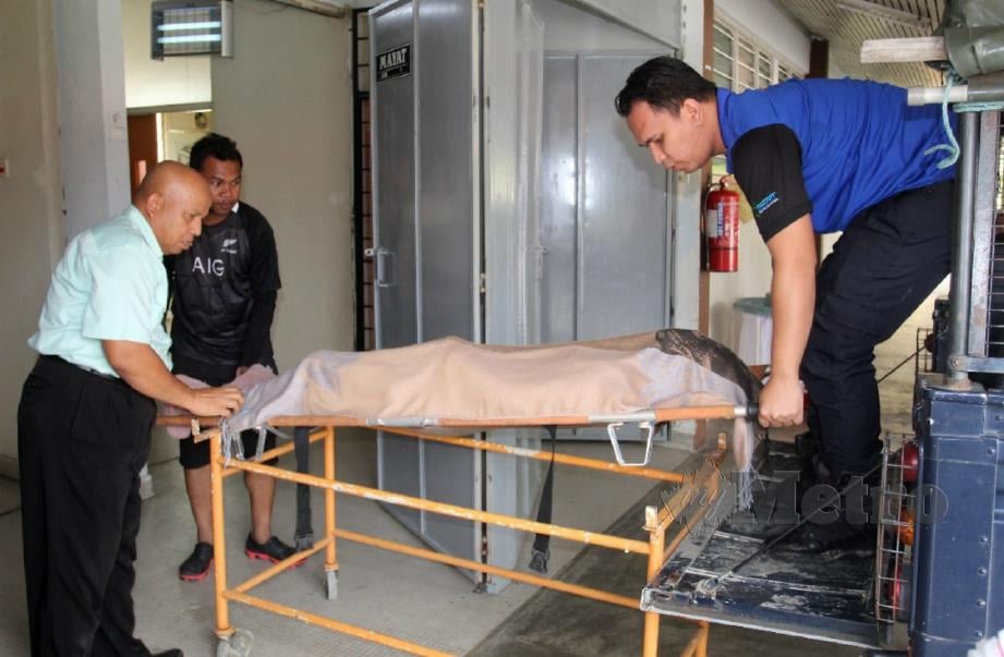 PETUGAS mengangkat mayat  Eh Phong Areang untuk dibedah siasat di Bilik Forensik Hospital Tumpat. FOTO Nik Abdullah Nik Omar.