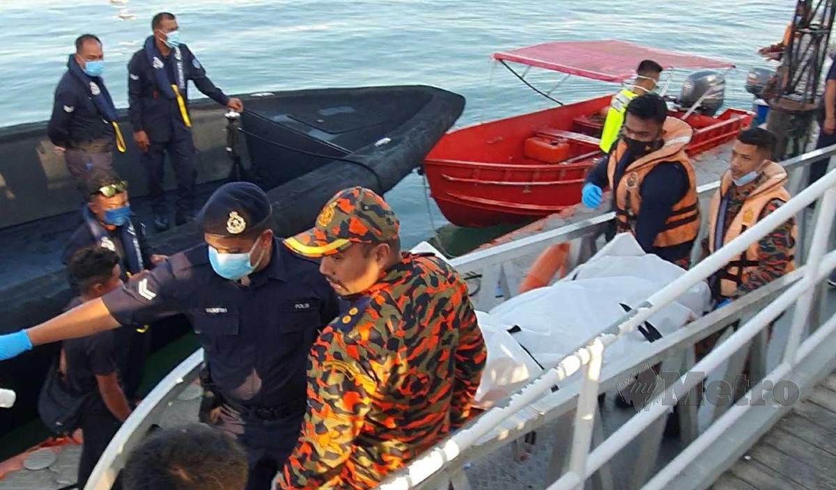 MAYAT Ahmad Nur Hassanuddin diusung pasukan penyelamat selepas ditemui terapung kira-kira 1.5 batu nautika dari lokasi kejadian di perairan Kuah, Langkawi.  FOTO Hamzah Osman