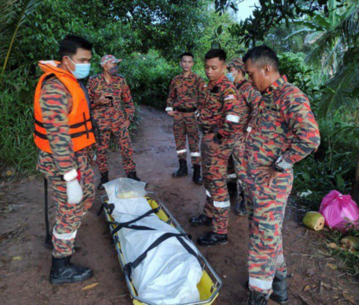 Anggota bomba disamping mayat Muhamad Amirul yang berjaya dijumpai di Sungai Benut, Pontian.FOTO TOGI MARZUKI