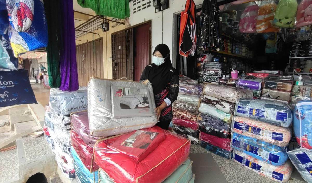 WAN Safuan menunjukkan cadar yang dijual di premisnya ketika ditemui di Pekan Rantau Panjang. FOTO Syaherah Mustafa