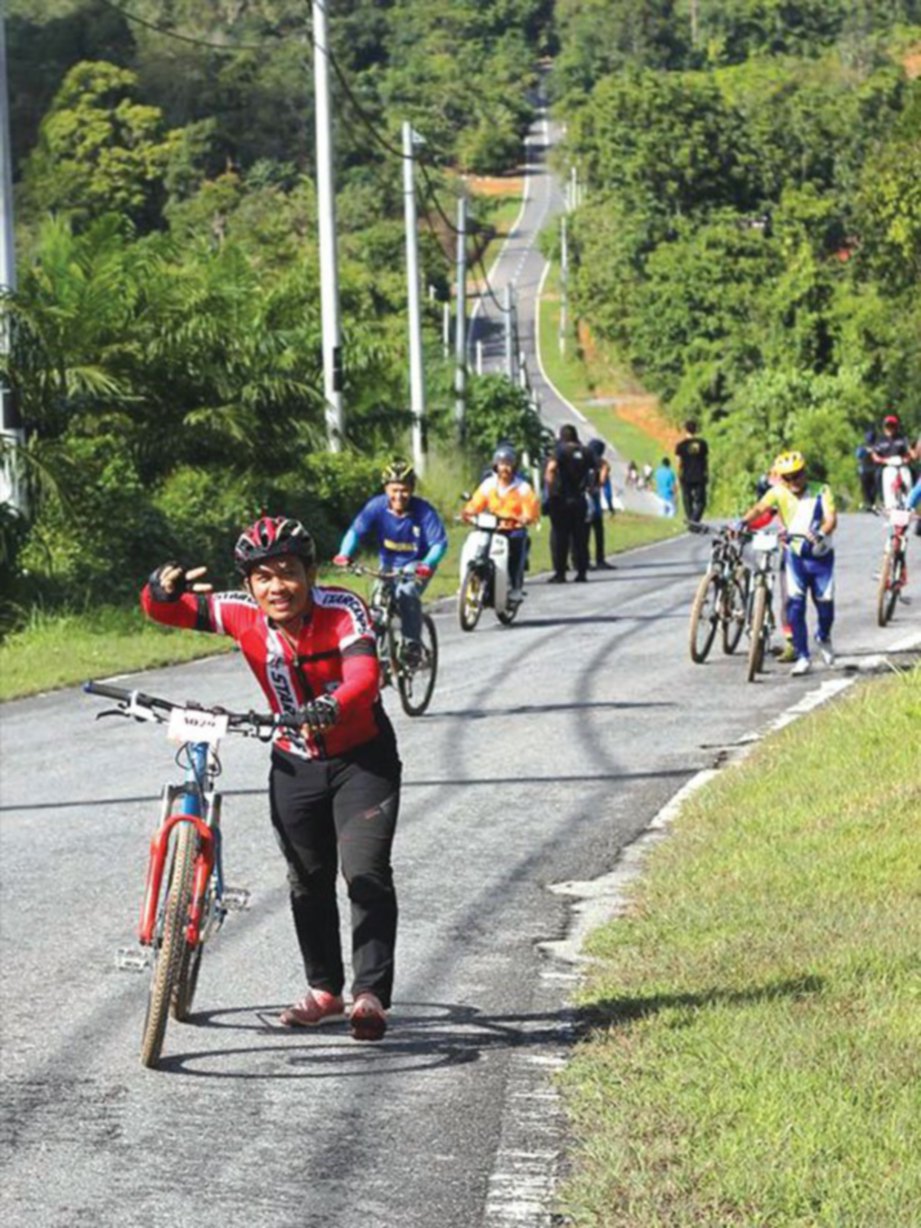  GELAGAT peserta menolak basikal ketika mendaki di kawasan Bukit Lenguh.