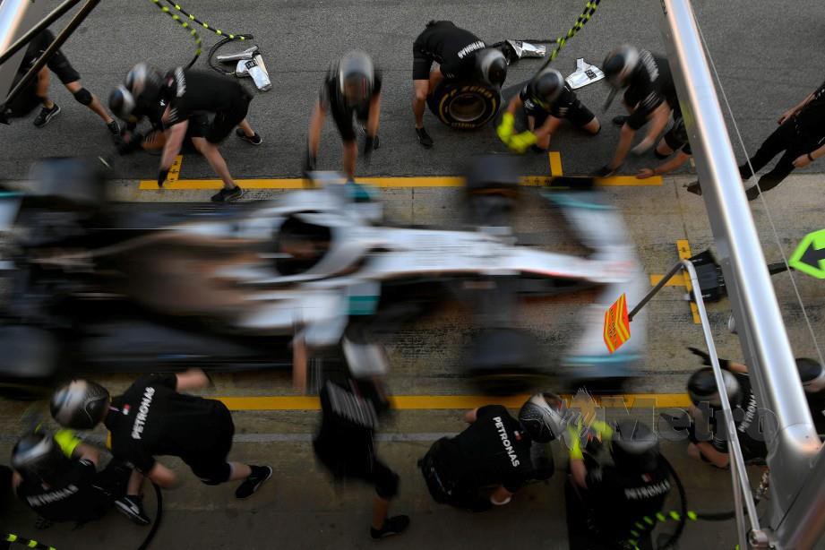JURUTEKNIK bertugas di kereta Hamilton di Litar de Catalunya, Montmelo menjelang GP Sepanyol, semalam. —  FOTO AFP