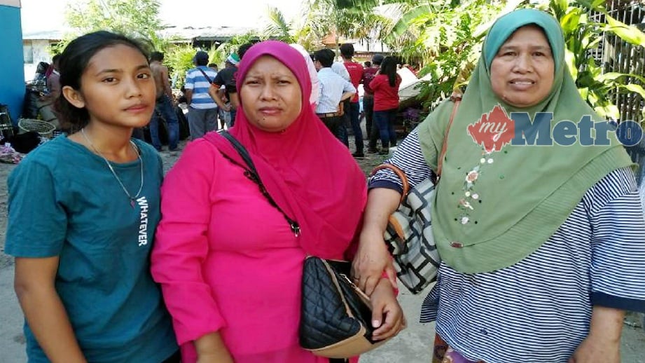 NURLIYANA (kiri) bersama ibu dan jiran selepas menyelamatkan diri dalam kebakaran di Kampung Cenderamata 2 di Likas, Kota Kinabalu, hari ini. FOTO Norasikin Daineh