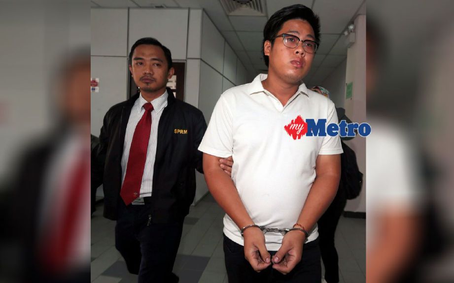Ng diiringi pegawai SPRM ketika dihadapkan ke mahkamah atas tuduhan memberi rasuah RM300 kepada penjawat awam di Mahkamah Sesyen Johor Bahru. FOTO Hairul Anuar Abd Rahim