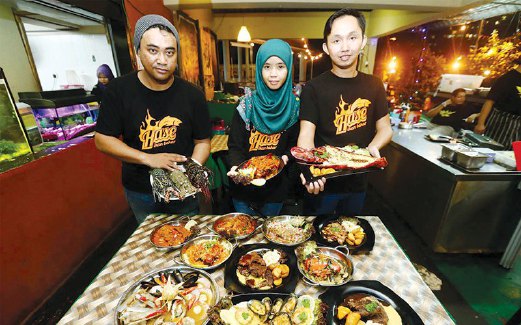ZULHELMI (kanan), isterinya, Hasnani Abdul Ghani (tengah) dan chef Shuhaimai Ismail menunjukkan antara menu terbaik Hase Ikan Bakar.