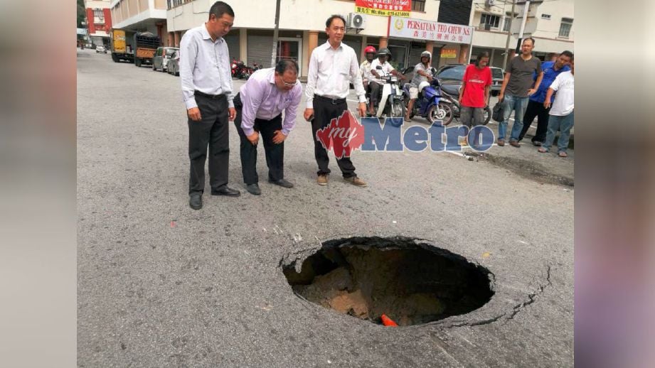  Siow (tengah) melihat lubang besar di Jalan Lee Sam yang membahayakan orang ramai. FOTO Mohd Amin Jalil