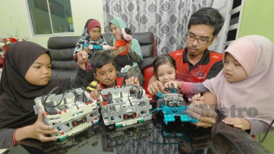 MAZLAN bersama ahli keluarganya yang terbabit dalam bidang robotik. FOTO Mohd Rafi Mamat. 