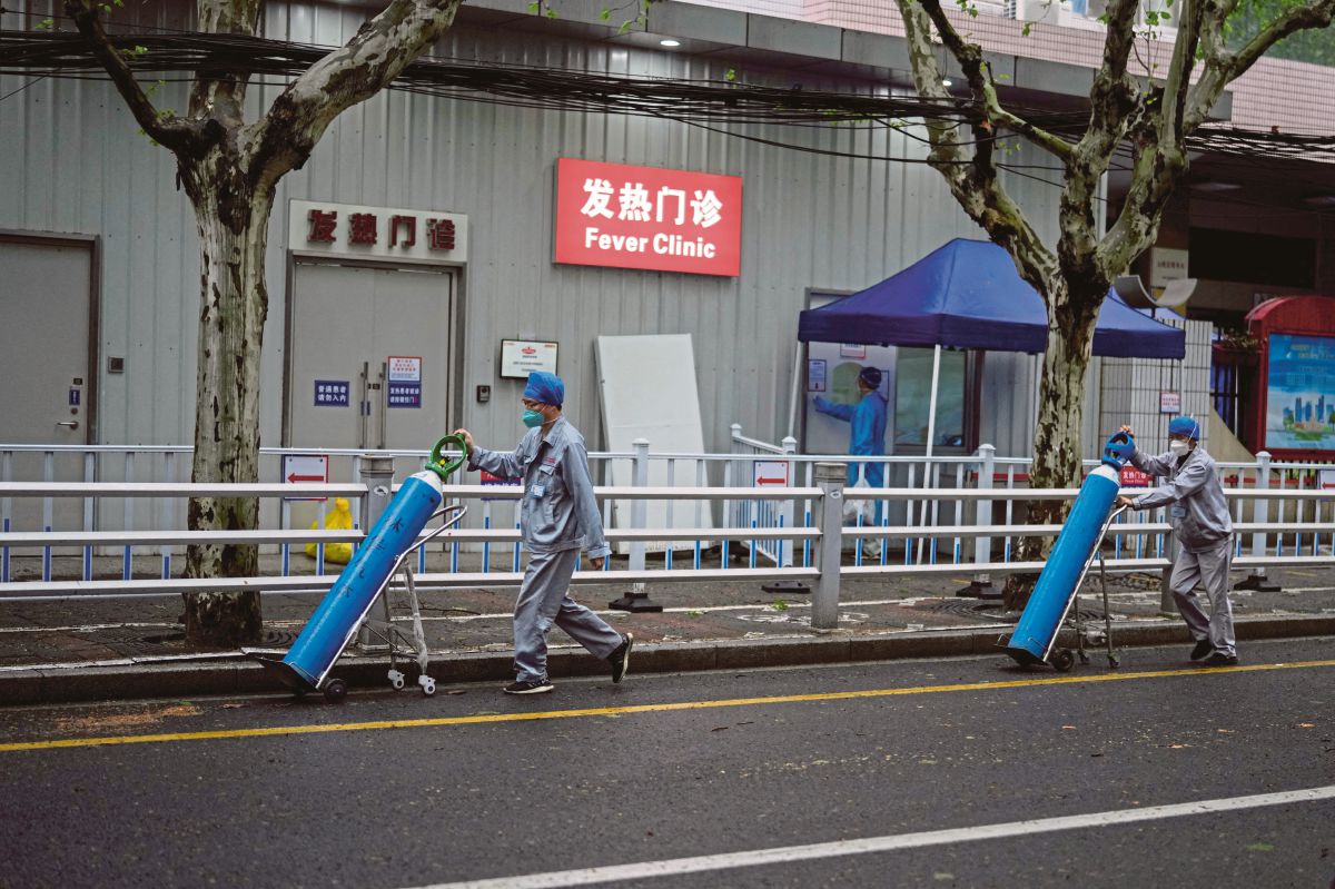 PEKERJA menghantar silinder oksigen ke sebuah klinik di Shanghai. FOTO Reuters