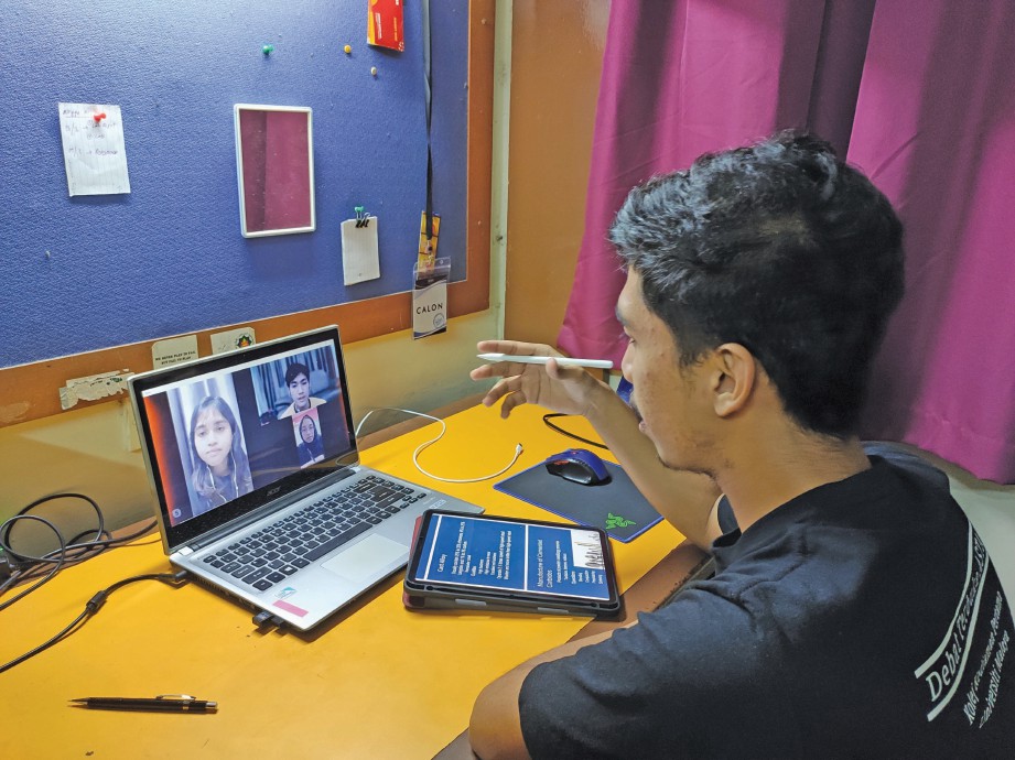 MOHAMAD Riyona Hidayat melakukan Skype bersama rakan-rakan untuk berbincang mengenai tugasan.