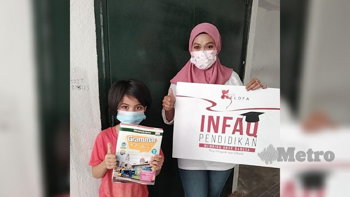 Sukarelawan PKN bersama murid asnaf yang menerima sumbangan buku aktiviti di PPR Kerinchi, Kuala Lumpur. Foto Hadzlan Hassan