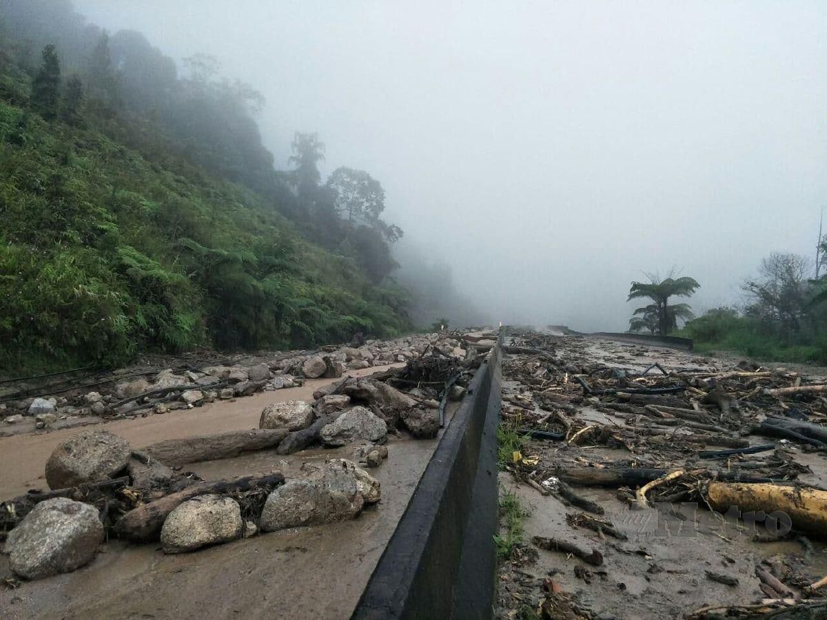 BUKIT runtuh menyebabkan jalan dipenuhi bongkah batu, kayu dan lumpur sejauh dua kilometer dekat Lojing, petang tadi. FOTO RAMLI IBRAHIM