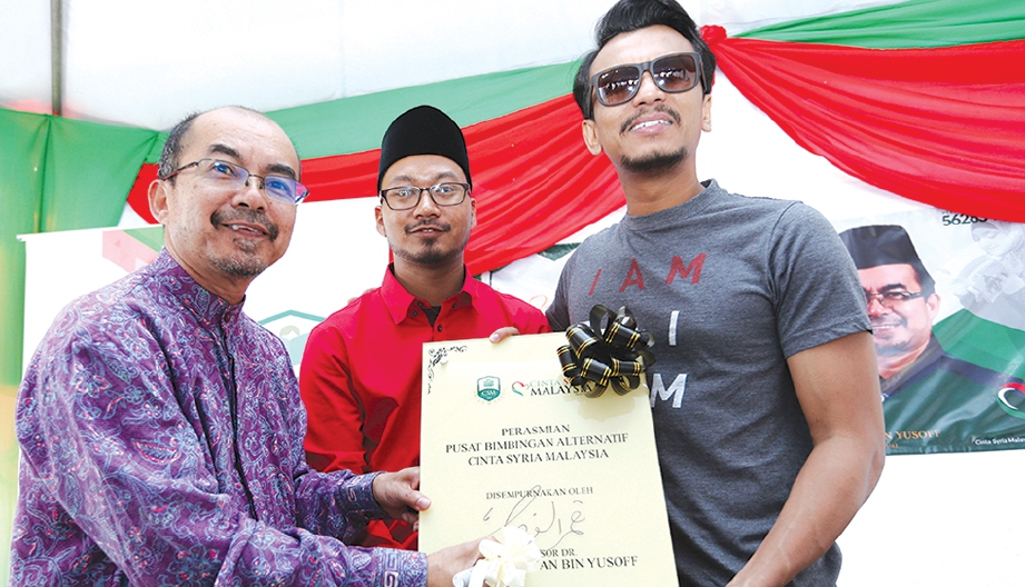 DR Kamaruzaman (kiri) menandatangani plak perasmian Pusat Bimbingan Alternatif Cinta Syria Malaysia (CSM) di Bandar Seri Putra, Bangi, baru-baru ini.