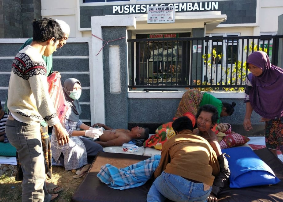ANGGOTA perubatan memberi bantuan kepada mangsa cedera susulan gempa bumi di Lombok. FOTO Reuters 