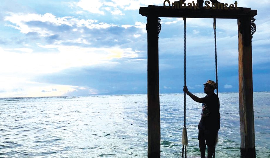 PENULIS menaiki buaian yang terdapat di pesisiran pantai Pulau Gili Terawangan.