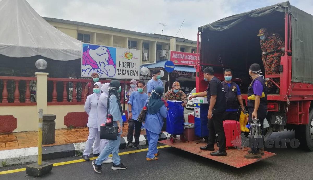 ANGGOTA bomba menggunakan lori untuk menghantar petugas kesihatan dari Hospital Kemaman ke PPS di sekitar daerah itu. FOTO ZATUL IFFAH ZOLKIPLY