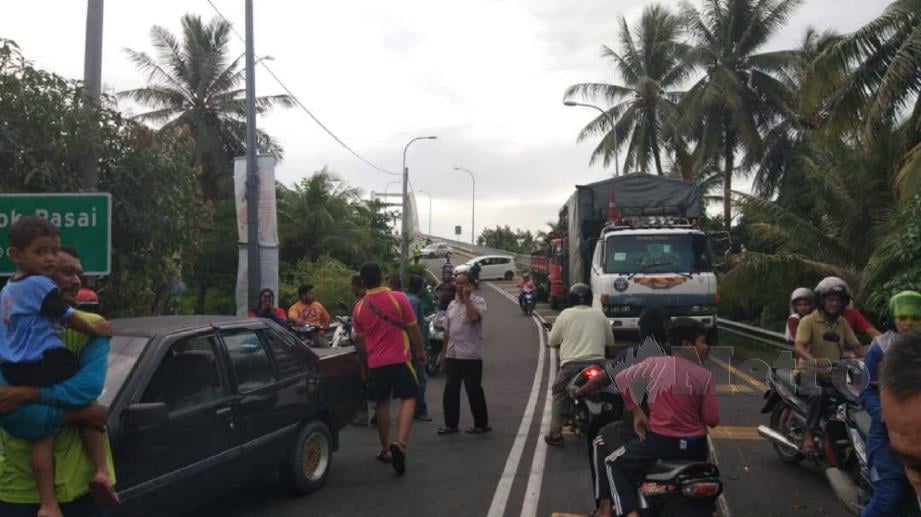 ORANG ramai memenuhi kawasan kemalangan membabitkan dua lori dan tujuh kereta di Jambatan Tok Pasai menghala ke Pekan Kuala Kedah di Alor Setar, hari ini. FOTO ihsan pembaca. 