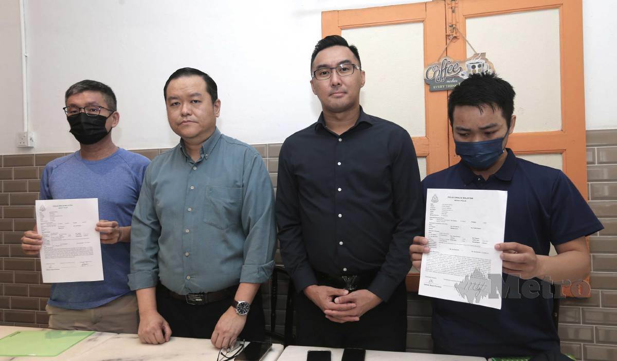 LOH Seow Hwa (kiri) menunjukkan laporan polis mengenai sindiket permerdagangan manusia di luar negara pada sidang media di Petaling Jaya. FOTO Amirudin Sahib