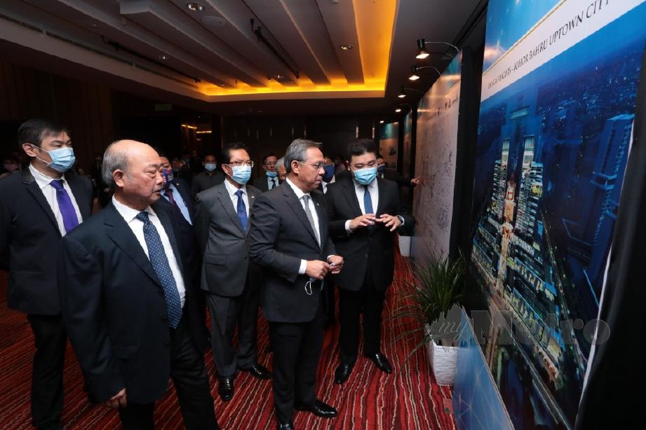 Hasni Mohammad (dua dari kanan) mendengar penerangan mengenai projek berskala besar yang akan dibangunkan Iskandar Waterfront Holdings (IWH) dan Metallurgical Corporation of China Ltd (MCCL). FOTO BERNAMA