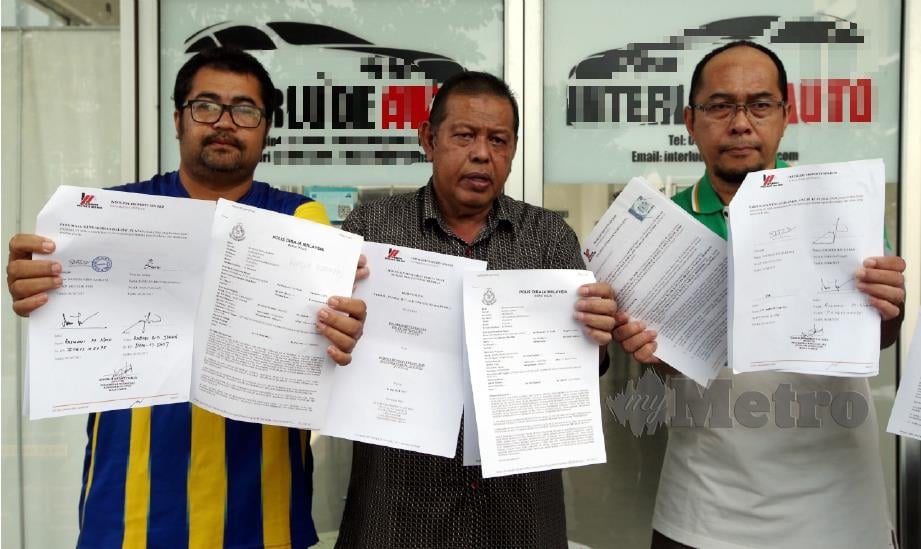 RASHIDI (tengah) bersama mangsa lain menunjukkan laporan polis dan dokumen perjanjian pajakan kereta di Pusat Komersial Taman Equine, Seri Kembangan, Serdang, hari ini. FOTO Mohd Khairul Helmy Mohd Din.