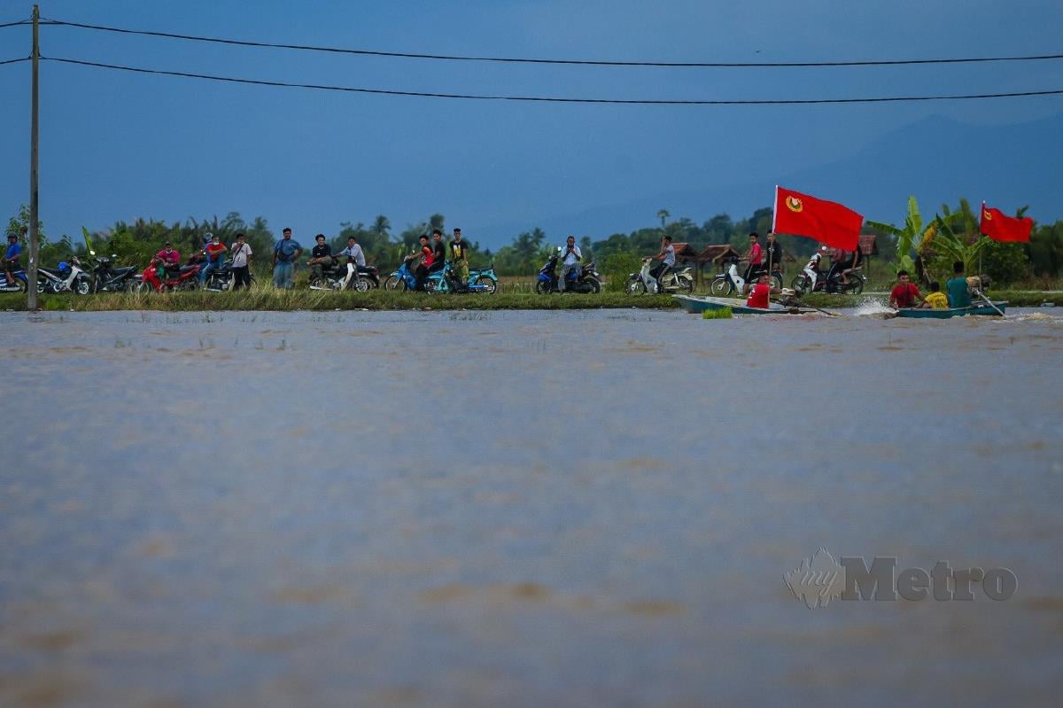 PENDUDUK kampung meninjau keadaan sawah yang dinaiki air di Kampung Kandai, Mukim Tajar akibat limpahan sungai Kedah pada 4 November lalu. FOTO LUQMAN HAKIM ZUBIR