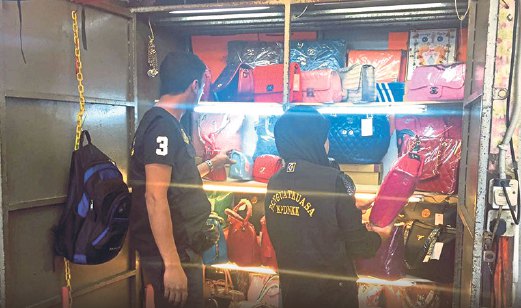 PEGAWAI KPDNKK memeriksa  beg tangan  dipercayai palsu yang dijual di Jalan Petaling.