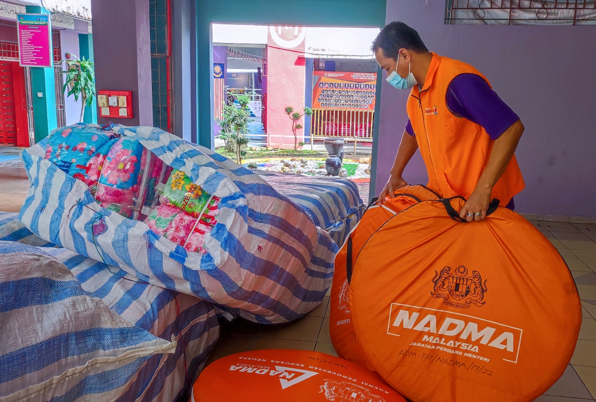 Kakitangan JKM Kelantan mengasingkan barangan seperti tilam, selimut dan tikar untuk diagihkan kepada mangsa banjir di Pusat Pemindahan Sementara (PPS) Sekolah Kebangsaan Kubang Batang hari ini. FOTO BERNAMA